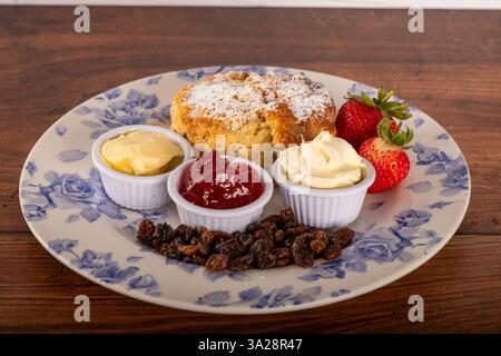 Ein Frucht Scone, Cream Tee mit Marmelade und Erdbeeren und Clotted Cremes Side Shot Stockfoto