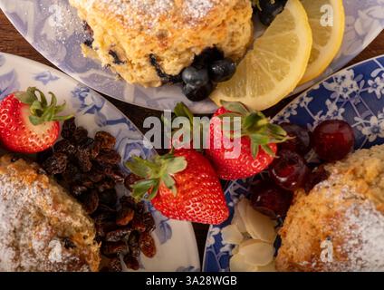 Drei Teller mit Erdbeeren, Heidelbeeren und Zitronenscheiben. Die Teller sind so angeordnet, dass das Essen appetitlich und einladend aussieht Stockfoto