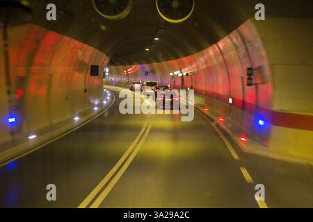 Fahrer Blick auf die Windschutzscheibe von einer öffentlichen Busfahrt im Fernbus, der durch einen mit künstlichem Licht beleuchteten Straßentunnel auf der gut gepflegten neuen Autobahn zwischen Split und Dubrovnik in Kroatien fährt. (138) Stockfoto