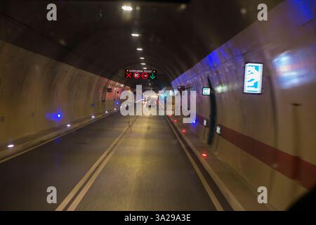 Fahrer Blick auf die Windschutzscheibe von einer öffentlichen Busfahrt im Fernbus, der durch einen mit künstlichem Licht beleuchteten Straßentunnel auf der gut gepflegten neuen Autobahn zwischen Split und Dubrovnik in Kroatien fährt. (138) Stockfoto