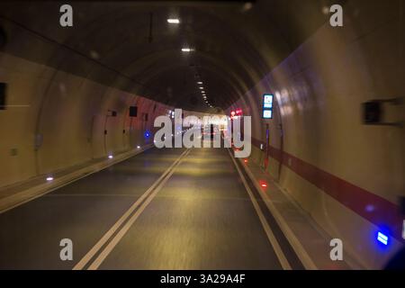 Fahrer Blick auf die Windschutzscheibe von einer öffentlichen Busfahrt im Fernbus, der durch einen mit künstlichem Licht beleuchteten Straßentunnel auf der gut gepflegten neuen Autobahn zwischen Split und Dubrovnik in Kroatien fährt. (138) Stockfoto