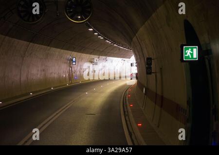Der Fahrer sieht die Windschutzscheibe aus einer öffentlichen Busfahrt im Fernbus, der durch den Straßentunnel auf der gut gepflegten neuen Autobahn zwischen Split und Dubrovnik in Kroatien fährt. Das Fahrzeug steht kurz davor, in das Tageslicht/Sonnenlicht zu gelangen. (138) Stockfoto