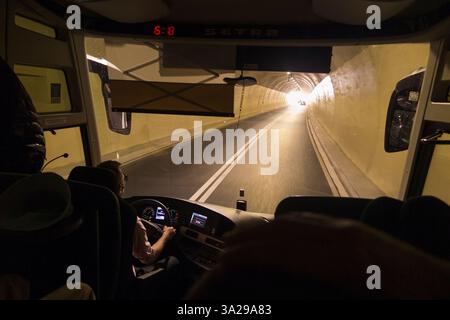 Der Fahrer sieht die Windschutzscheibe aus einer öffentlichen Busfahrt im Fernbus, der durch den Straßentunnel auf der gut gepflegten neuen Autobahn zwischen Split und Dubrovnik in Kroatien fährt. Das Fahrzeug steht kurz davor, in das Tageslicht/Sonnenlicht zu gelangen. (138) Stockfoto