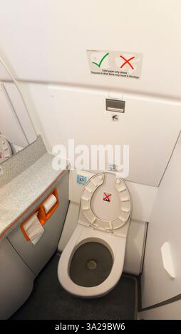 Toilette/Toilette eines Airbus A319-Flugzeugs/Badezimmer auf einem Flugzeug-/Flugzeug-/Flugzeugflug. Das Bild ist eine Panoramaaufnahme von mehr als einem Bild, das zusammengefügt ist, wodurch der Toilettensitz leicht verzerrt wird. (138) Stockfoto