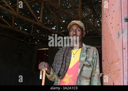 ÄTHIOPIEN, Bezirk Yechila, Dorf SHEWEATE HUGUM, zerstörte Schule während des Tigray-Krieges 2020-2022 zwischen den mit der äthiopischen Bundesregierung und Eritrea verbündeten Kräften und der Tigray Volksbefreiungsfront TPLF, TPLF Fighter / Äthiopien, Tigray, Folgen des Tigray Kriege 2020-2022, Distrikt Yechila, Dorf SHEWEATE HUGUM, zerstörte Schule, Gerse Tadese, Tigrayischer Kämpfer der TPLF, 51 Jahre alt, sein Sohn ist im Krieg gefallen mit 22 Jahren, Gewehr Einschüsse Stockfoto
