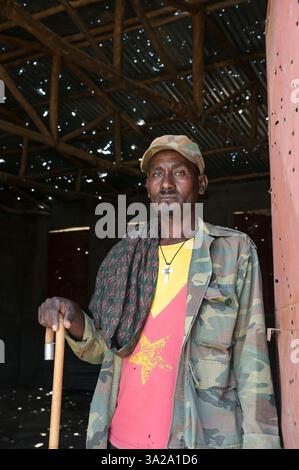 ÄTHIOPIEN, Bezirk Yechila, Dorf SHEWEATE HUGUM, zerstörte Schule während des Tigray-Krieges 2020-2022 zwischen den mit der äthiopischen Bundesregierung und Eritrea verbündeten Kräften und der Tigray Volksbefreiungsfront TPLF, TPLF Fighter / Äthiopien, Tigray, Folgen des Tigray Kriege 2020-2022, Distrikt Yechila, Dorf SHEWEATE HUGUM, zerstörte Schule, Gerse Tadese, Tigrayischer Kämpfer der TPLF, 51 Jahre alt, sein Sohn ist im Krieg gefallen mit 22 Jahren, Gewehr Einschüsse Stockfoto