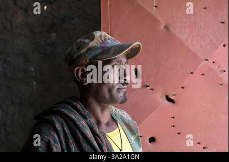 ÄTHIOPIEN, Bezirk Yechila, Dorf SHEWEATE HUGUM, zerstörte Schule während des Tigray-Krieges 2020-2022 zwischen den mit der äthiopischen Bundesregierung und Eritrea verbündeten Kräften und der Tigray Volksbefreiungsfront TPLF, TPLF Fighter / Äthiopien, Tigray, Folgen des Tigray Kriege 2020-2022, Distrikt Yechila, Dorf SHEWEATE HUGUM, zerstörte Schule, Gerse Tadese, Tigrayischer Kämpfer der TPLF, 51 Jahre alt, sein Sohn ist im Krieg gefallen mit 22 Jahren, Gewehr Einschüsse Stockfoto