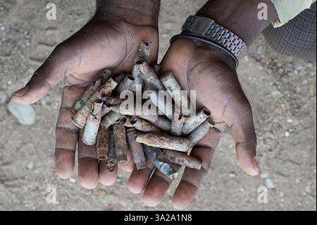 ÄTHIOPIEN, Bezirk Yechila, Dorf SHEWEATE HUGUM, zerstörte Schule während des Tigray-Krieges 2020-2022 zwischen den mit der äthiopischen Bundesregierung und Eritrea verbündeten Kräften und der Tigray Volksbefreiungsfront TPLF, TPLF-Kämpfer mit Patronen / Äthiopien, Tigray, Folgen des Tigray Kriege 2020-2022, Distrikt Yechila, Dorf SHEWEATE HUGUM, zerstörte Schule, Gerse Tadese, Tigrayischer Kämpfer der TPLF, 51 Jahre alt, sein Sohn ist im Krieg gefallen mit 22 Jahren, Patronenhülsen Stockfoto