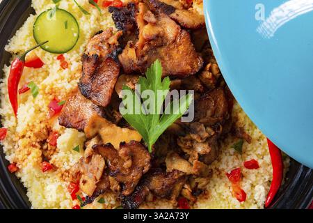 Tajin mit Couscous, Gemüse und Fleisch auf weißem Hintergrund Stockfoto
