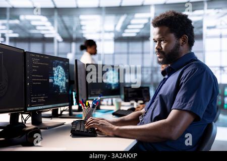 IT-Spezialist im Serverraum, der KI-Systeme mit High-Performance-Computing-Engine auf einem PC entwickelt. afroamerikaner im Rechenzentrum entwickelt künstliche Intelligenz mit kognitiven Fähigkeiten Stockfoto