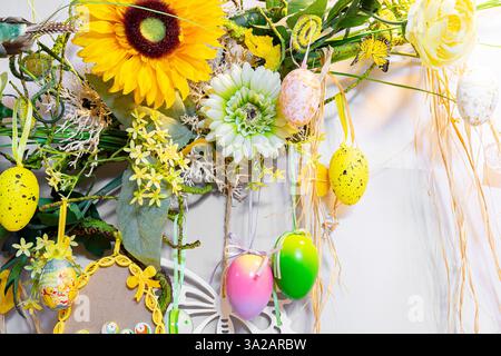 Frühling und Ostern hängende Wanddekorationen mit bunten Ostereiern, Blumen und Schmetterling, Origami-Dekorationen, Wohnkultur, weißer Hintergrund. Stockfoto