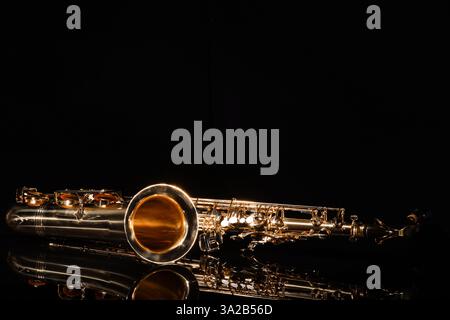 Jazz. Ein Saxophon auf Spiegelfläche vor schwarzem Hintergrund, Platz für Text Stockfoto