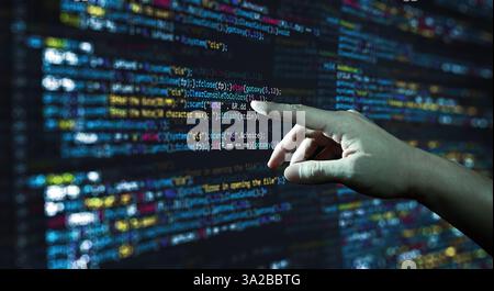 Menschliche Hand, die auf die abstrakte moderne Technologie des Programmierens von Code-Bildschirmen zeigt. C Programmiersprache für Computerskript und Technologie Stockfoto