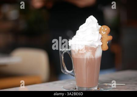 Warmes Getränk garniert mit Schlagsahne und Kekse im Café Stockfoto