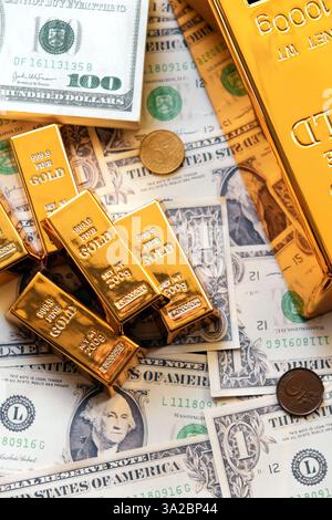 Goldbarren auf dem Hintergrund von Dollarscheinen. Der Begriff des Wohlstands Stockfoto