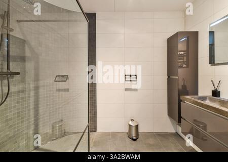 Elegantes und modernes Bad mit eleganten Armaturen, stilvollen Schränken und minimalistischer Einrichtung für ein luxuriöses Erlebnis. Stockfoto