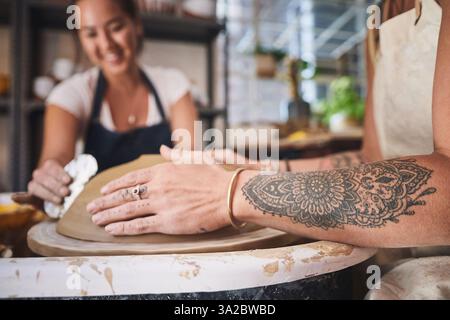 Menschen-, Hände- und Töpferunterricht für das Team, arbeiten zusammen und schnitzen Ton für keramisches Handwerk. Unterricht, Ausrüstung und Hilfe beim Unterricht an Stockfoto