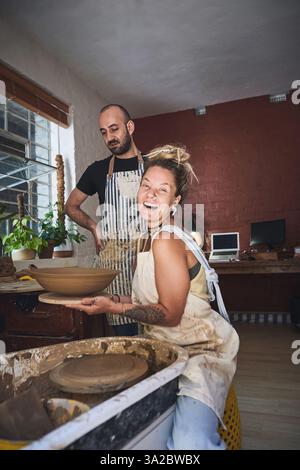 Menschen, Team und Töpferunterricht im Porträt, arbeiten zusammen und schnitzen Ton für keramische Handwerke. Unterricht, Ausrüstung und Hilfe beim Unterricht an Stockfoto
