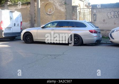 Lombardei, Italien 1. März 2025 eleganter, silberner BMW 5er Touring-Parkplatz entlang der historischen Cremona Street mit kontrastierenden schwarzen Felgen gegen Tradi Stockfoto