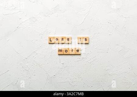 Weniger ist mehr Wort auf Holz Block geschrieben. Weniger ist mehr Text auf den Tisch, Konzept. Stockfoto