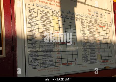 Am Bahnhof Surat Thani, Thailand, werden Abfahrtszeiten, Ziele und Bahnsteignummern auf Thai und Englisch angezeigt Stockfoto