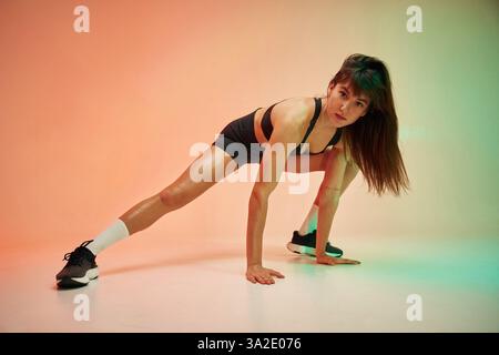 Eine junge Frau in Fitnesskleidung ist im Studio. Stockfoto