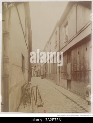 Eugène Atget fotografiert im April 1899 die Passage des Patriarches und hebt ihren engen, historischen Charakter und die für Pariser Passagen typischen architektonischen Merkmale hervor. Stockfoto