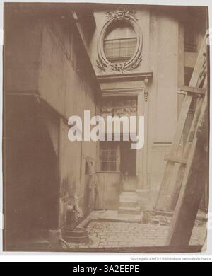 Eine Fotografie des Hofes von Hôtel Colbert in Paris, aufgenommen von Eugène Atget im August 1899, die die architektonischen Elemente des Raumes betont. Stockfoto