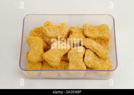 Hausgemachte rohe Hühnernuggets auf Lebensmittelbehälter, gefrorene Lebensmittel Zubereitung Stockfoto