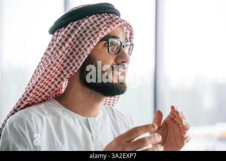 Profil Hochformat. Erfolgreicher muslimischer Geschäftsmann in traditioneller Kleidung in seinem Büro. Stockfoto