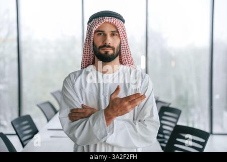 Vorstellung des reichen Menschen. Erfolgreicher muslimischer Geschäftsmann in traditioneller Kleidung in seinem Büro. Stockfoto