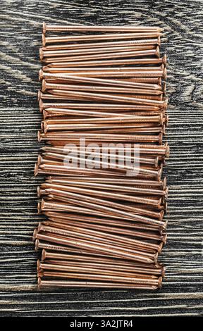 Stapel von Kupfernägeln auf Holzbrett Stockfoto