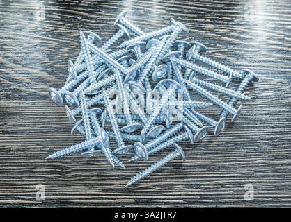 Stapel rostfreier Schrauben auf Holzbrett Stockfoto