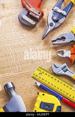 Satz von Werkzeugen organisiert im Copyspace Hammer Tapeline Lineal Bleistiftschlüssel Zange Cutter on Holzboard Construction Konzept Stockfoto