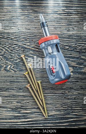 Schraubendreher Messingschrauben auf Holzplatte Stockfoto