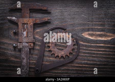 Verrostet veraltete Messschieber und Zahnrad bei Vintage-Holzbrettbaukonzept Stockfoto