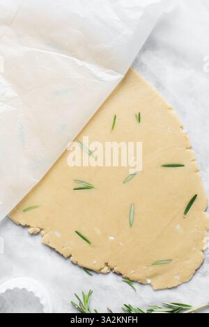 Draufsicht auf ausgerollten Rosmarinzucker-Keksenteig, Prozess der Herstellung von ausgeschnittenen Zuckerkeksen Stockfoto