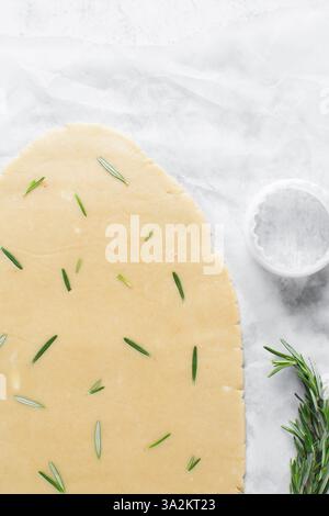Draufsicht auf ausgerollten Rosmarinzucker-Keksenteig, Prozess der Herstellung von ausgeschnittenen Zuckerkeksen Stockfoto