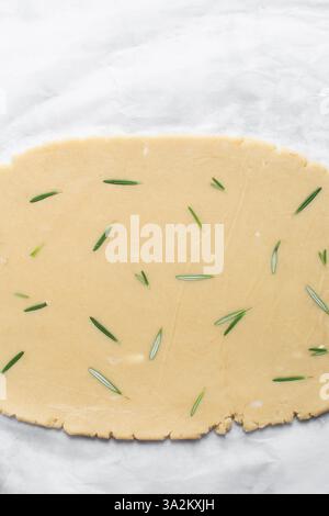 Draufsicht auf ausgerollten Rosmarinzucker-Keksenteig, Prozess der Herstellung von ausgeschnittenen Zuckerkeksen Stockfoto