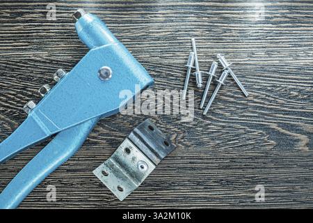 Satz Nietzange Nietschrauben auf Holzbrett Stockfoto