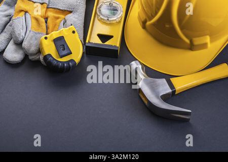Tapeline Handschuhe Level Hammerhelm auf schwarzem Hintergrund Stockfoto