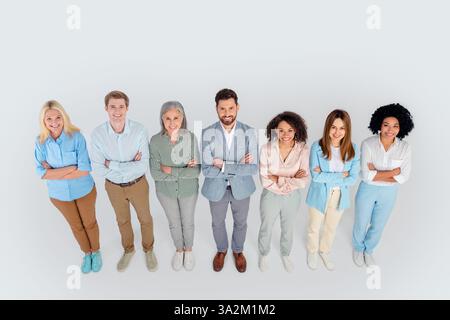 Gruppe von verschiedenen Geschäftsleuten, die sich selbstbewusst in formeller Bürokleidung auf neutralem grauem Hintergrund ausgeben Stockfoto