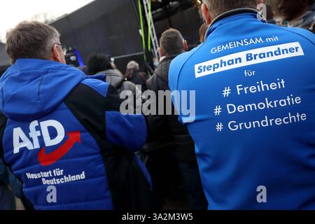 AFD-Anhänger trägt Jacke mit Schriftzug: NEUSTART FÜR DEUTSCHLAND - Logo: AFD - AfD-Anhänger trägt Jacke mit Schriftzug: GEMEINSAM mit Stephan Brandner rechtsextremer deutscher Politiker der AfD für Freiheit Demokratie Grundrechte - AfD-Abschlusskundgebung zur vorgezogenen Bundestagswahl am 23. Februar 2025 auf dem Erfurter Domplatz. - Deutschland, DE, DEU, Deutschland, Erfurt, 22.02.2025: Björn Höcke Vorsitzende der AfD-Fraktion im Thüringer Landtag und andere Redner sprechen zu ihren Anhängern. Laute Polizei hatten sich im speziell mit Gittern abgesperrten Bereich der AfD-Kundgebung um 1,100 Stockfoto