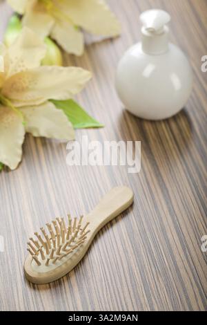 Runde Flasche und Haarbürste mit Blume Stockfoto