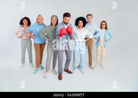 Ein vielfältiges Team von Profis, das sich selbstbewusst in formalwear präsentiert und Teamarbeit und Zusammenarbeit auf grauem Hintergrund repräsentiert Stockfoto