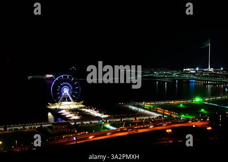 Abendlicher Blick auf Baku. Beleuchtete Skyline von Baku, Aserbaidschan bei Nacht mit Lichtern von Gebäuden, die sich im Wasser spiegeln. Stockfoto
