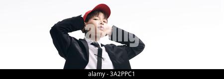 Der junge gutaussehende asiatische Mann posiert selbstbewusst und verbindet moderne Mode mit einer energiegeladenen Atmosphäre. Stockfoto