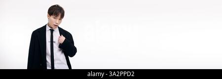 Ein fesselnder junger Mann zieht mit einem formellen Outfit und selbstbewusster Atmosphäre die Aufmerksamkeit auf sich. Stockfoto