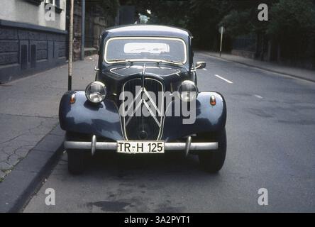 1960er Jahre, historisch, ein französisches Auto, ein Citroen Traction Avant, parkt neben einem Bürgersteig auf einer Straße, Frankreich. Der in den frühen 1930er Jahren entwickelte Traction Avant – französisch für Frontantrieb – war ein innovatives Fahrzeug, das zum ersten Mal in Serienfertigung einen Frontantrieb hatte, eine Monocoque-Karosserie, also ohne separate Chasis und Allround-Einzelradaufhängung. Erstmals 1934 hergestellt, gab es mehrere Modelle und Varianten des ursprünglichen Modells. Hier ist die größere „normale“ Version der 1950er Jahre zu sehen, die länger und mit einem größeren Motor ausgestattet ist. Viele betrachten den Traction Avant als das einflussreichste Fahrzeug, das jemals gebaut wurde. Stockfoto