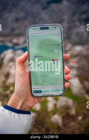 Kotor, Montenegro – Januar 2,2025: Nahaufnahme einer Hand, die das iPhone hält und Google Maps anzeigt, das moderne Navigationssystem und digitale Wegsuche symbolisiert Stockfoto
